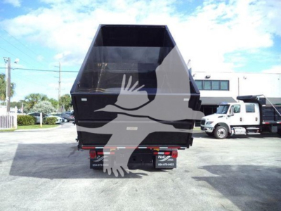 Dump truck dump bed and rear view showing storage hopper with International Durastar 4300 tailgate and truck in background.