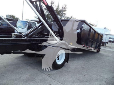 Truck bed of a 2019 International Durastar 4300 roll-off truck showing hydraulic crane components and dump bed with white wheel rim.