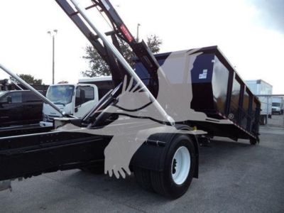 Truck chassis and roll-off hoist with dump body from a 2019 International Durastar 4300, side view showing rear wheel and hydraulic arm mechanism.