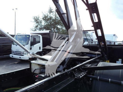 Truck body with roll-off crane arm and hydraulic components visible; no legible labels or text specific to fluids visible in image.
