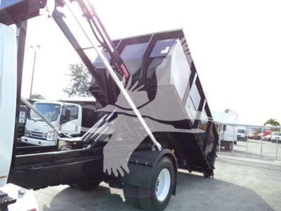 Truck cab and dump bed in raised position shown from side with hydraulic arms visible.