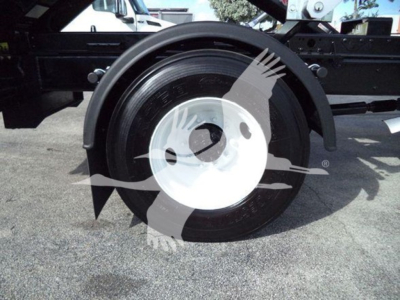 Truck wheel and fender area with a large white hubcap, part of a roll-off truck chassis visible.
