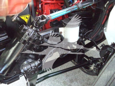 Truck engine bay showing hydraulic fluid reservoir and linkage in a 2019 International Durastar 4300 roll-off truck.
