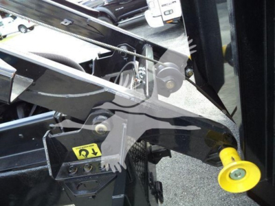 Truck chassis close-up showing lifting arm and yellow jack pad on International Durastar 4300 componentry.