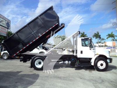 Truck side view showing a white 2019 International Durastar 4300 roll-off, dumping raised bed, stock number T15012, VIN 1HTMMMML4KH515012, used condition.