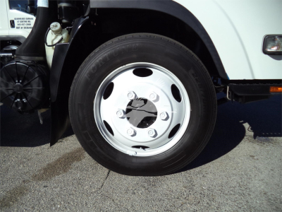 Isuzu NPRR front wheel showing steel wheel with central plastic hub and lug nuts, part of dump truck chassis