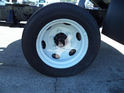 Isuzu NPRR truck wheel with white steel rim and black tire, undercarriage visible.