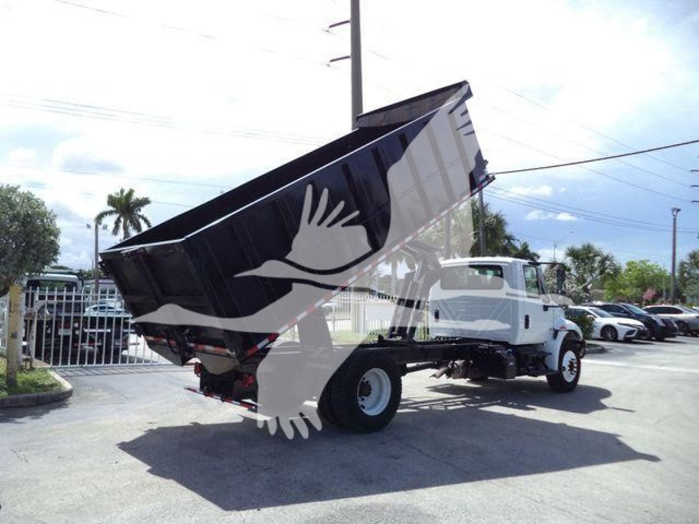 Dump truck bed raised on a 2019 International 4300 dump truck with stock number T83647FM visible in listing; image shows truck and rear dump bed.