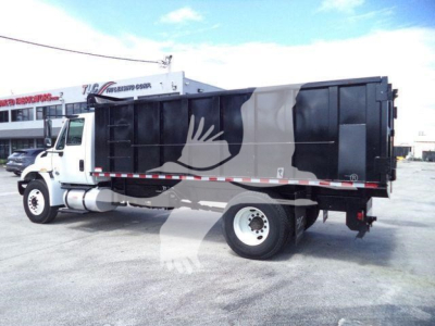 Dump truck with black and gray dump body showing stock number and category signage; side view of 2019 International 4300 dump truck.