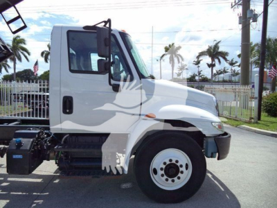 International 4300 dump truck cab-side view showing chassis with front wheel and door text not visible.