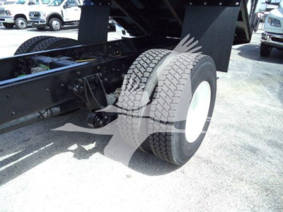 Truck rear dual tires on a dump truck chassis showing wheel and suspension components.