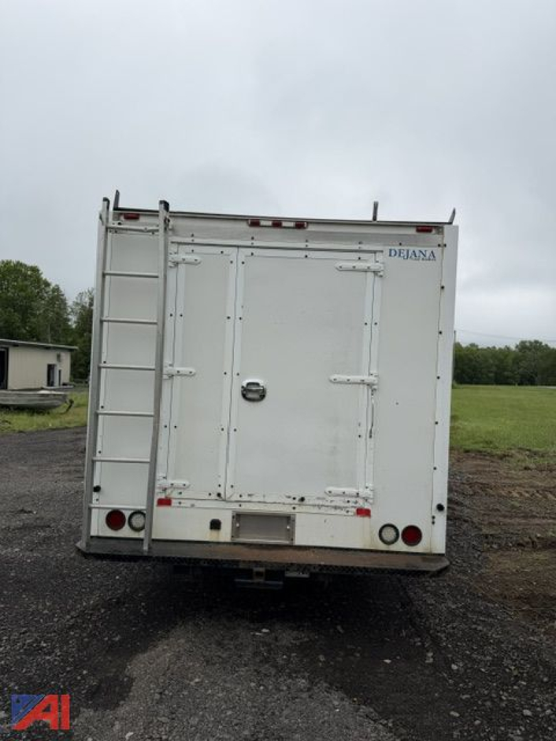 Isuzu NPR box truck rear view showing back doors, a vertical ladder on left side, and a small Dejana logo near top right of the cargo area.
