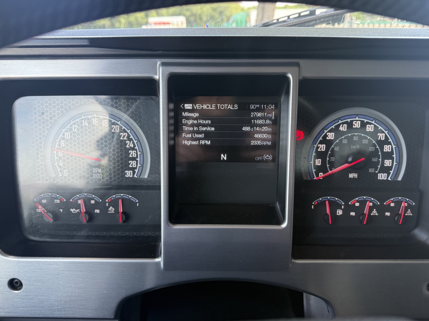 Mack GR64F dash cluster showing instrument gauges and central display with vehicle totals readout.