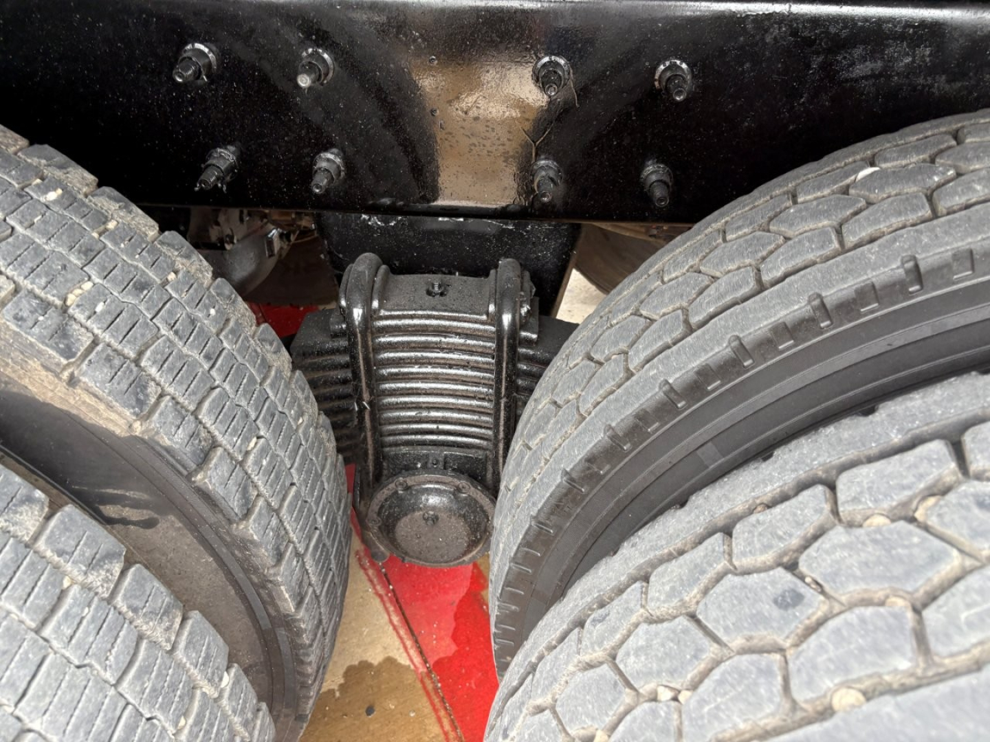 Rear view showing dual rear axles and differential housing on Mack GR64F truck.