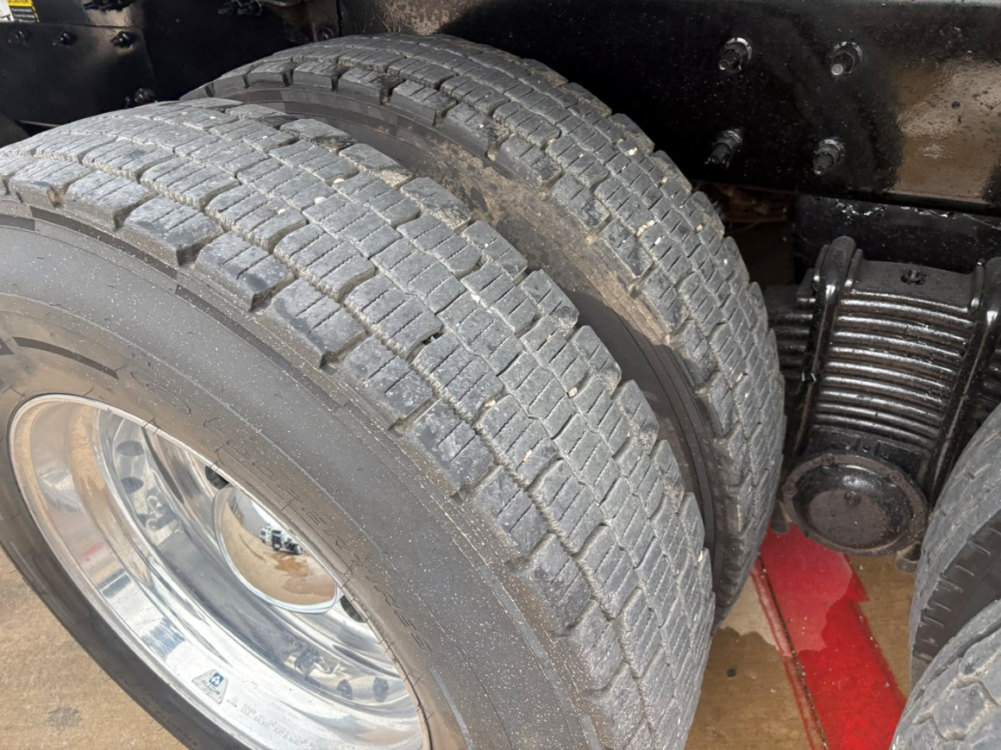 Mack GR64F truck showing dual rear wheels and suspension with tire treads visible.