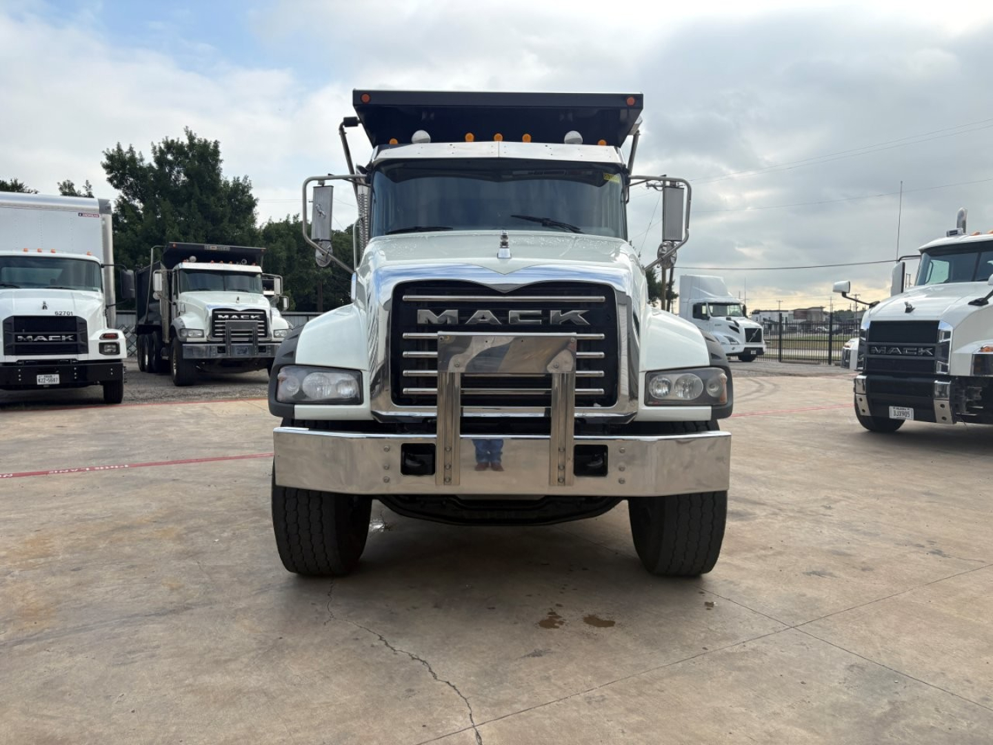 Mack GR64F dump truck front view showing grille, bumper guard, and roof lights.