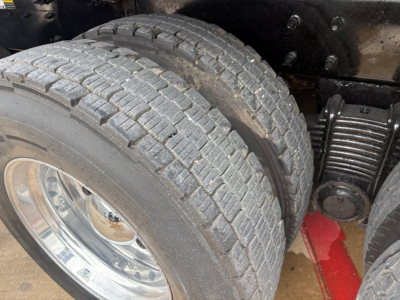 Mack GR64F truck showing dual rear wheels and suspension with tire treads visible.