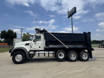 Dump truck side view showing 2021 Mack GR64F with white cab and black dump body, six-wheel configuration, stock number B3433P.