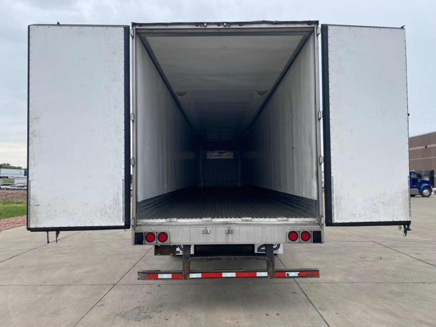 Rear view of a 2021 Utility refrigerated trailer with open doors showing empty interior and loading ramp.