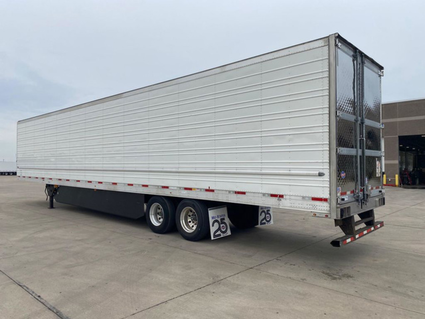 Trailer side view of a 2021 utility refrigerated trailer in used condition showing triple axle with silver ribbed sides.
