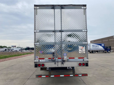 Rear view of a 2021 refrigerated trailer with diamond plate door panels, dual doors, and bumper, parked on lot.