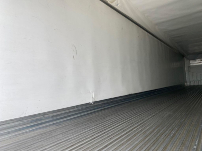 Utility reefer trailer interior showing empty metal walls and ribbed floor. No visible labels.