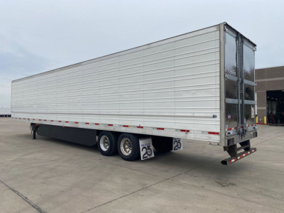 Trailer side view of a 2021 utility refrigerated trailer in used condition showing triple axle with silver ribbed sides.
