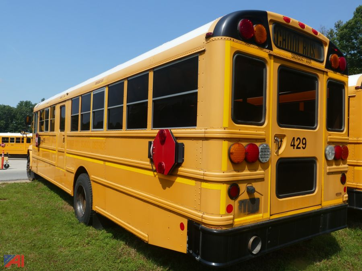 School bus left rear view showing yellow body, black-trimmed windows, rear bumper, and bus number 429.