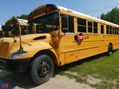 School bus exterior showing stop sign, yellow body, bus number 429, and emergency exit door along a row of school buses.