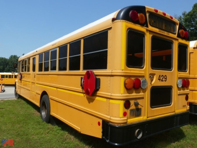 School bus left rear view showing yellow body, black-trimmed windows, rear bumper, and bus number 429.