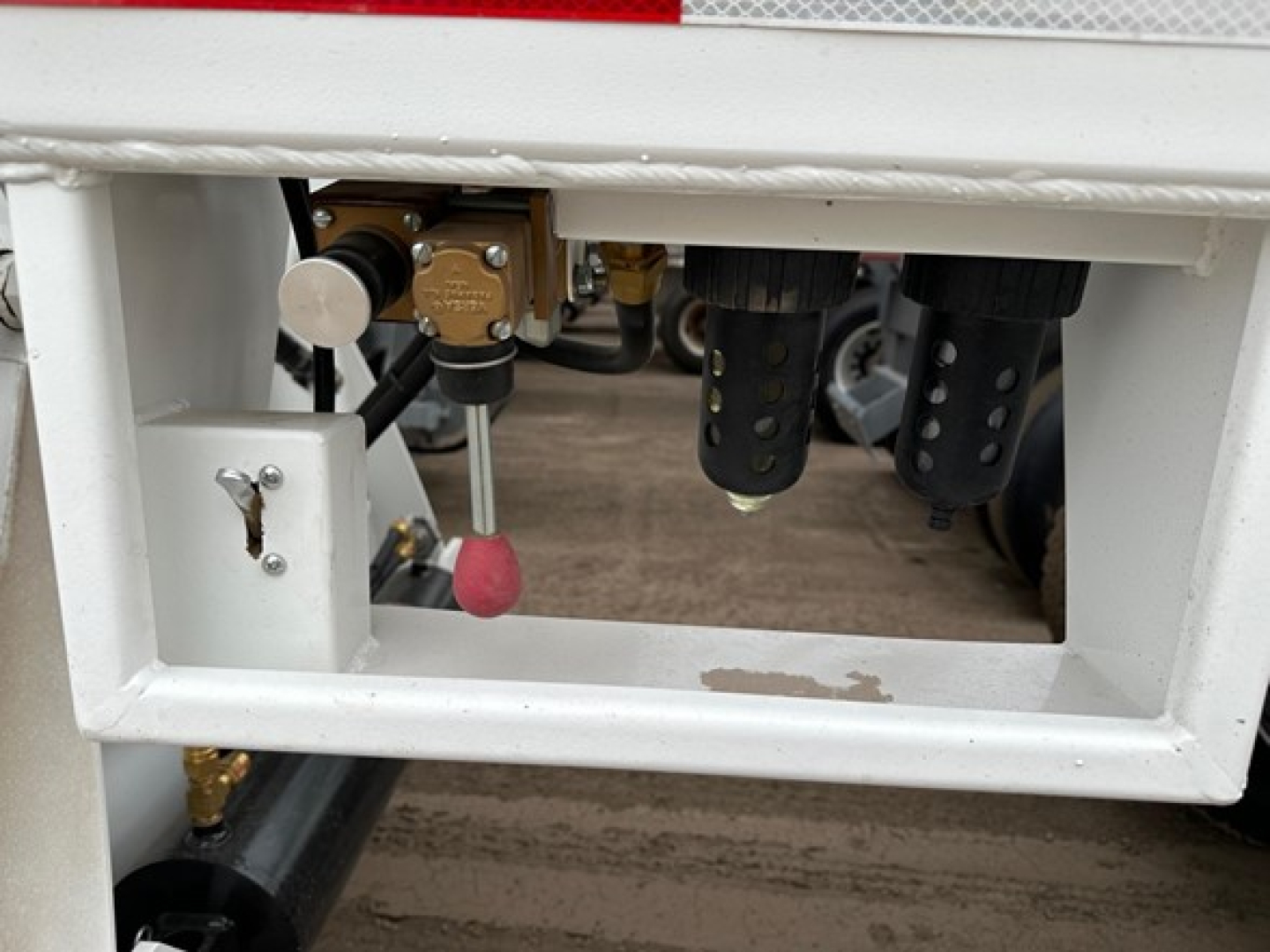 Bottom dump trailer top front frame showing control valve and hydraulic piping assembly.