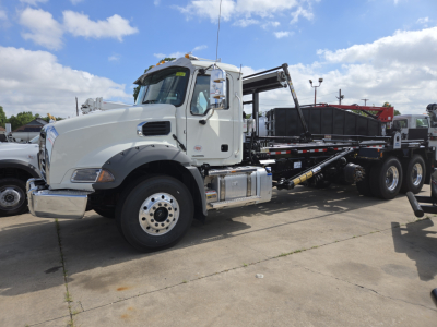 Truck roloff Mack GR64B side view showing cab, chassis, and hydraulic equipment with hooklift arms and container bed.