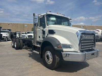 2026 Mack GR64B cab forward truck shown in side/front view with chrome bumper, large grille, dual rear axles, and side exhaust.