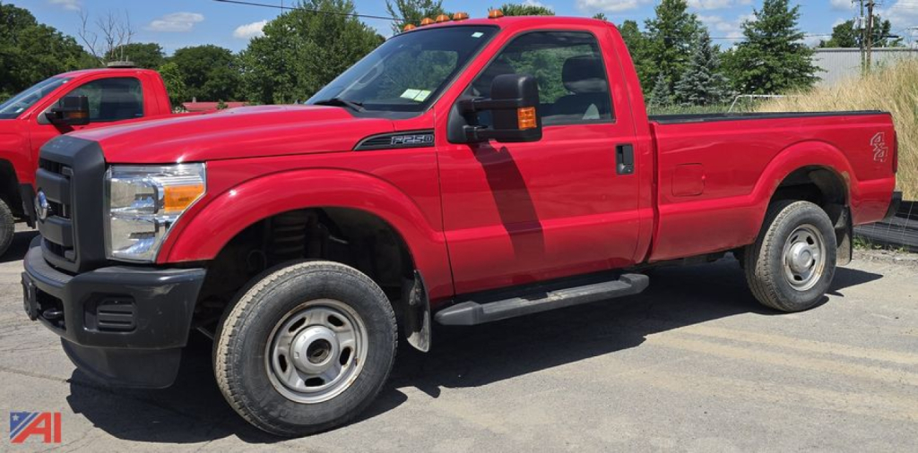 Ford F-250 Super Duty XL single-cab long-bed pickup truck in red, side view with extended mirrors, steel wheels, and black bumper in a lot.