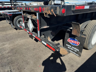 Trailer rear view showing flatbed trailer with Utility logo, rear lights, and wheel, stock number UE11423, VIN 150119763322, flatbed/ trailer components visible.