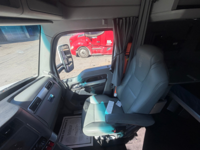 Kenworth T680 truck cabin interior showing driver's seat and dashboard with window, curtain, and side mirror.