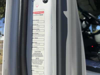 Kenworth T680 label on door jamb showing truck model and weight and caution notes visible.