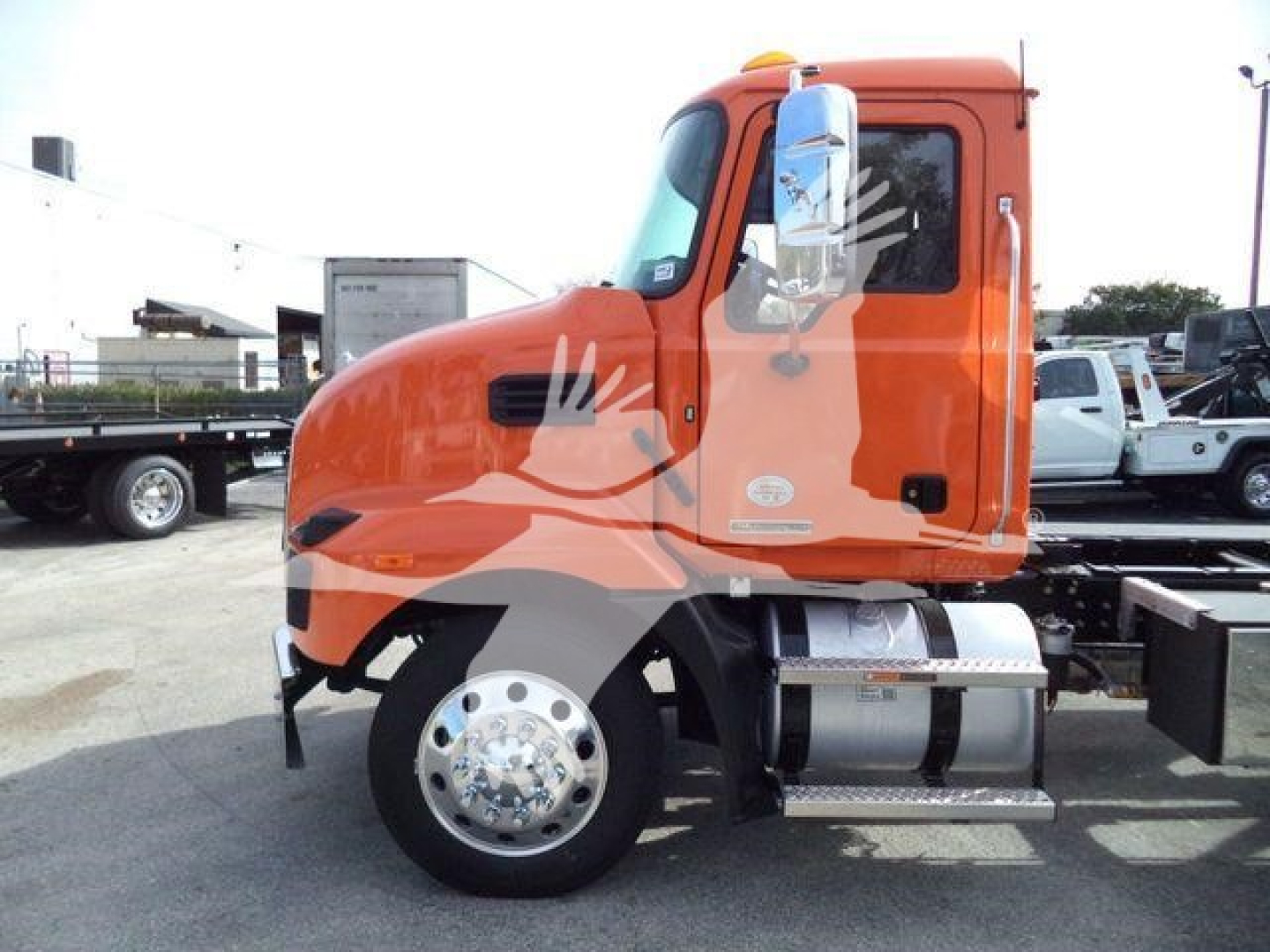 Medium shot of a bright orange Mack MD6 truck cab side profile showing front wheel, fuel tank, and step.