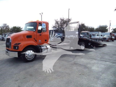 Orange 2026 Mack MD6 rollback tow truck in a dealership lot with a deployed flatbed and other trucks in background.