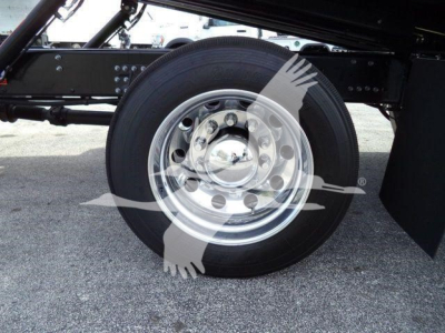 Truck chassis side view showing a large steel rim wheel with tire and black undercarriage components.