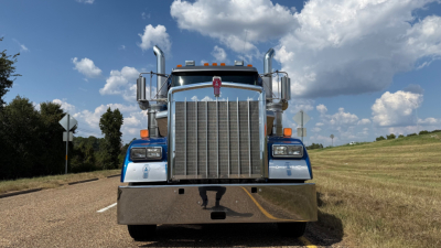 Kenworth W900 truck front view showing large chrome grille and bumper with blue accents