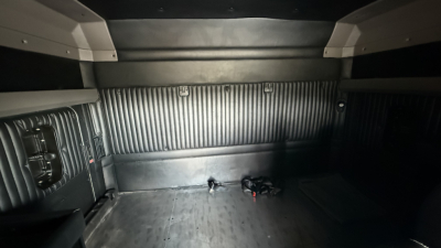Kenworth truck interior cargo area showing ribbed metal walls and floor with a small bundle of wires near the rear wall.