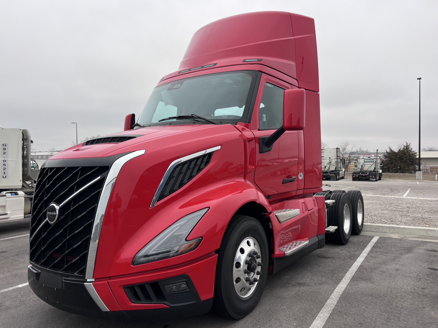 Volvo VNL64T300 2025 conventional daycab front-left view showing cab and grille; red color; no plate visible.