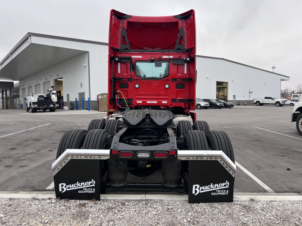 Volvo VNL64T300 truck rear view showing chassis and dual rear axles with mud flaps, red cab, and Bruckner's Equipment mud flaps.