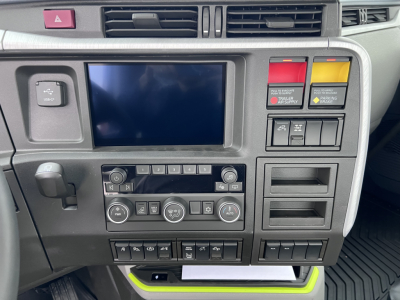 Volvo VNL64T300 cab interior showing center 8-inch display, climate controls, switch panel, and storage pockets.