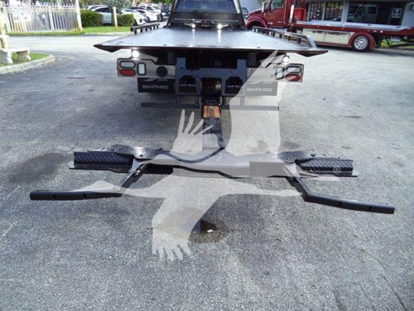 Rear view of a 2022 Ford F600 rollback truck showing the towing hitch and chassis undercarriage components.