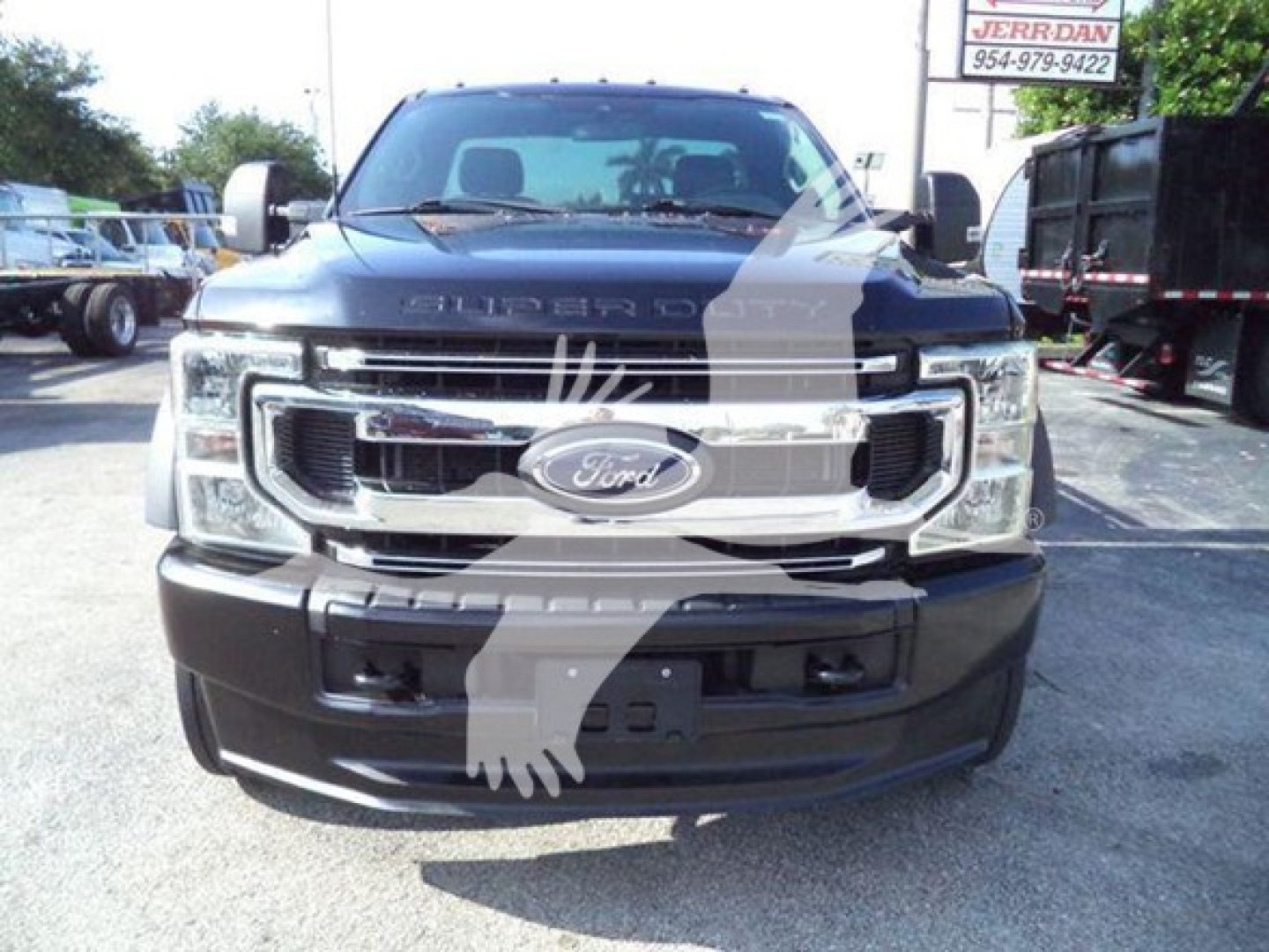 Ford F-600 truck front view showing chrome grille with Ford emblem and bumper, in-service vehicle in a dealership lot.