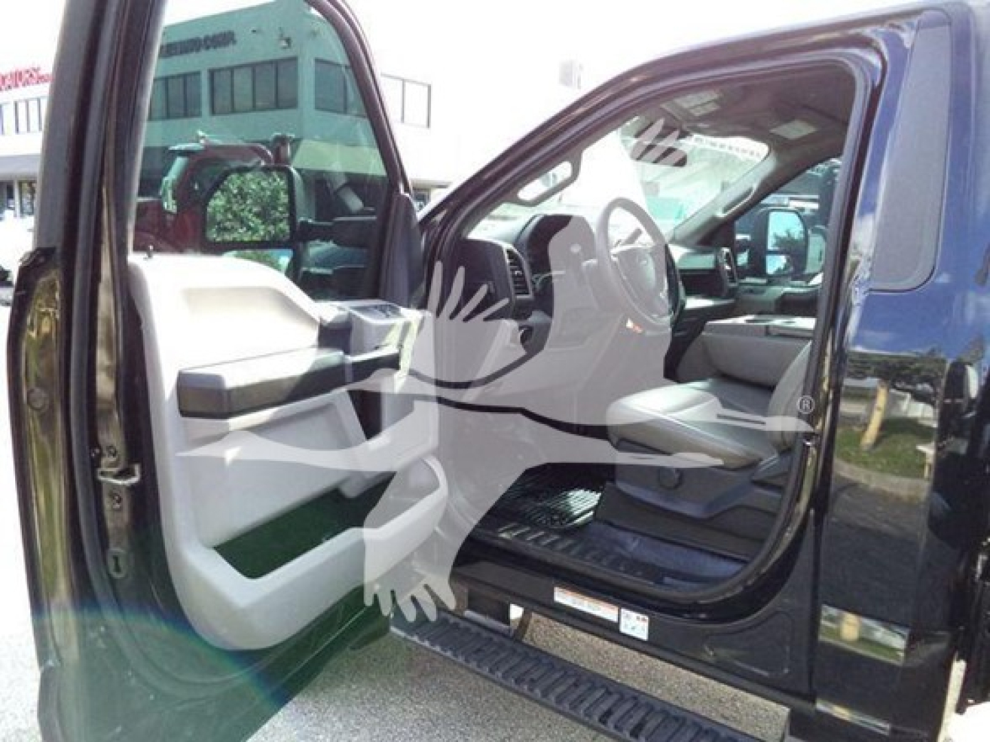 Cab interior of a Ford F-600 rollback showing open driver door with interior panel and steering wheel visible.