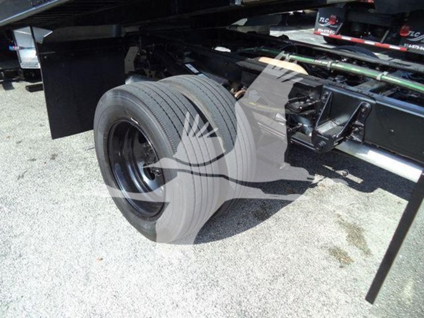 Truck wheel and undercarriage showing rear dual tires and frame components.