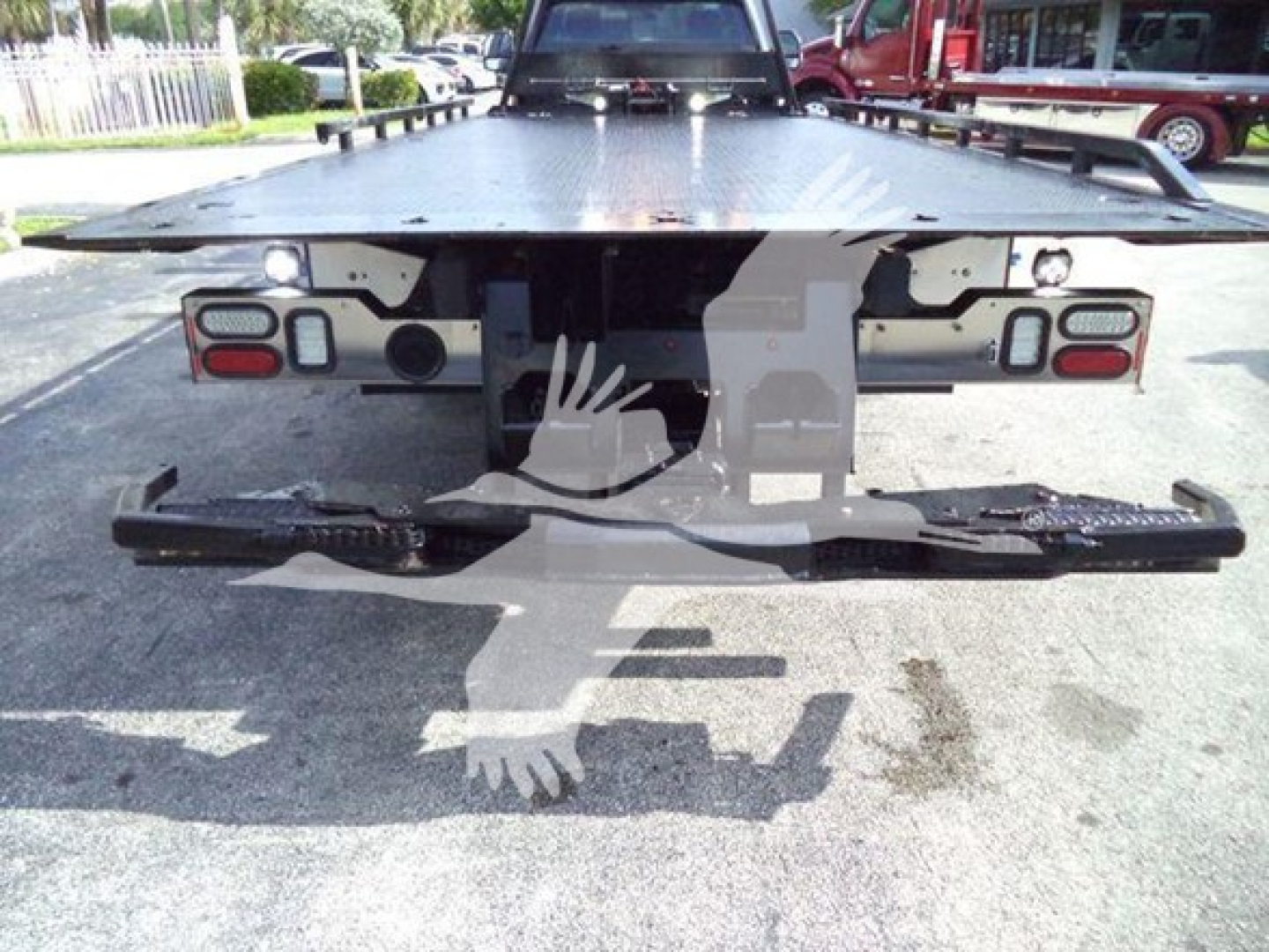 Rear view of a 2022 Ford F600 rollback truck showing bumper, taillights, and a flatbed with mounting hardware; no legible text visible on labels in image.